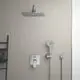 Duschpaneel mit einer großen Kopfbrause und Handbrause von Ideal Standard, befestigt an einer hellen Wand, integriert in einem modernen Badezimmer-Setup.